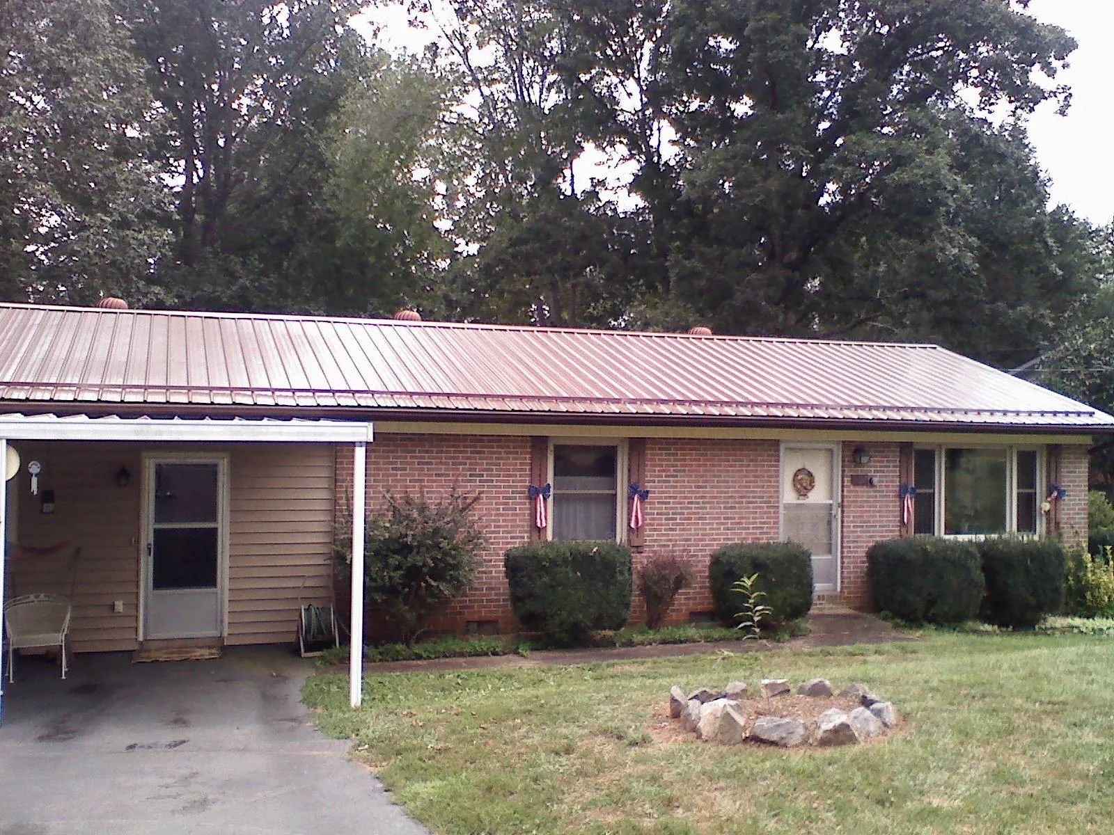 Bronze metal roof and carport on a brick ranch home — Roof Repair work by our crew in Olmstead