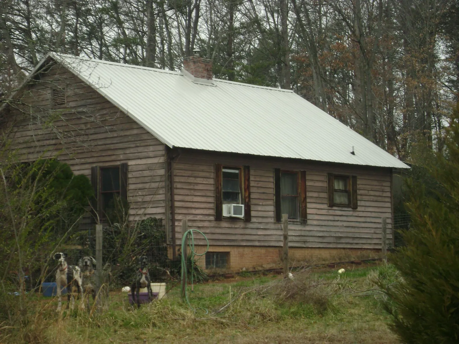 White metal roof on an old wood sided farmhouse, from a Metal Roof Installation job in Olmstead